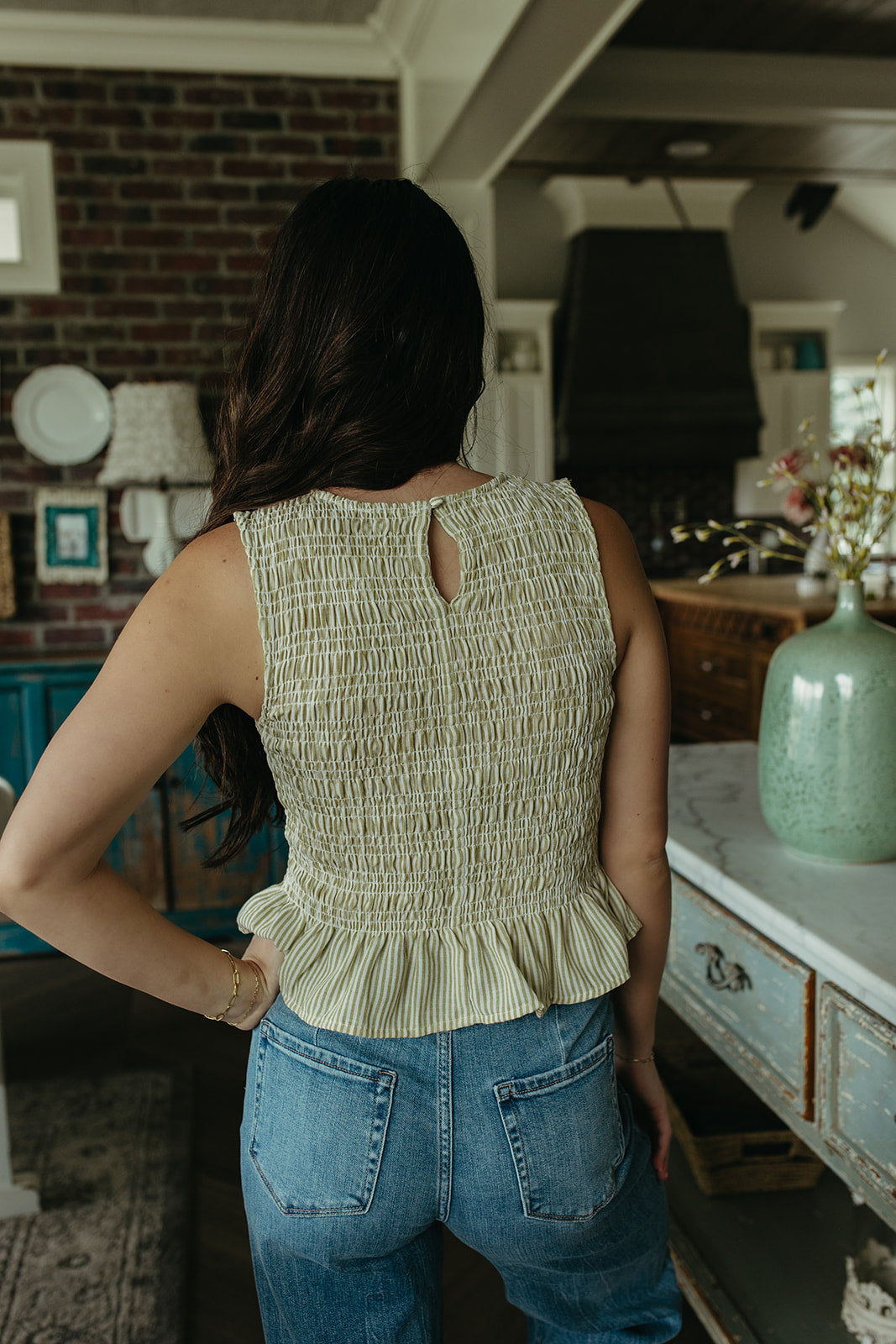 THE STORY SMOCKED PEPLUM TOP IN GREEN