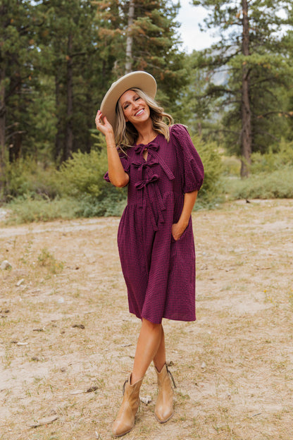 THE HARLOW BOW DRESS IN BURGUNDY CHECKERED BY PINK DESERT