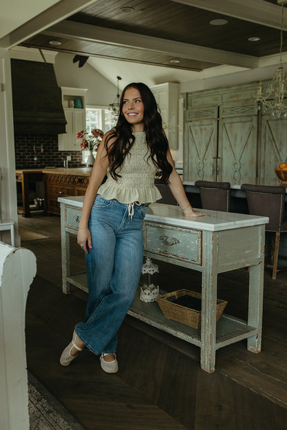 THE STORY SMOCKED PEPLUM TOP IN GREEN