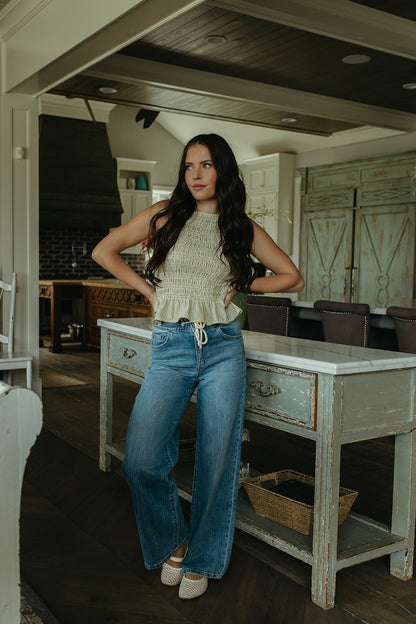 THE STORY SMOCKED PEPLUM TOP IN GREEN