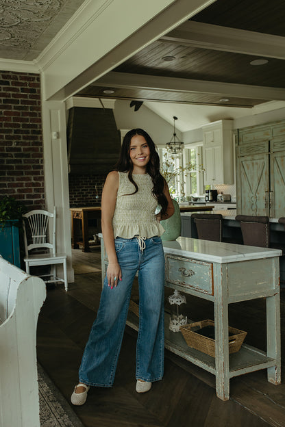 THE STORY SMOCKED PEPLUM TOP IN GREEN