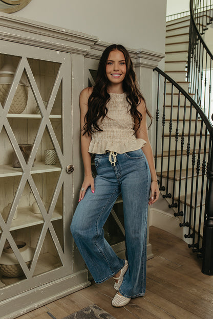 THE STORY SMOCKED PEPLUM TOP IN TAUPE