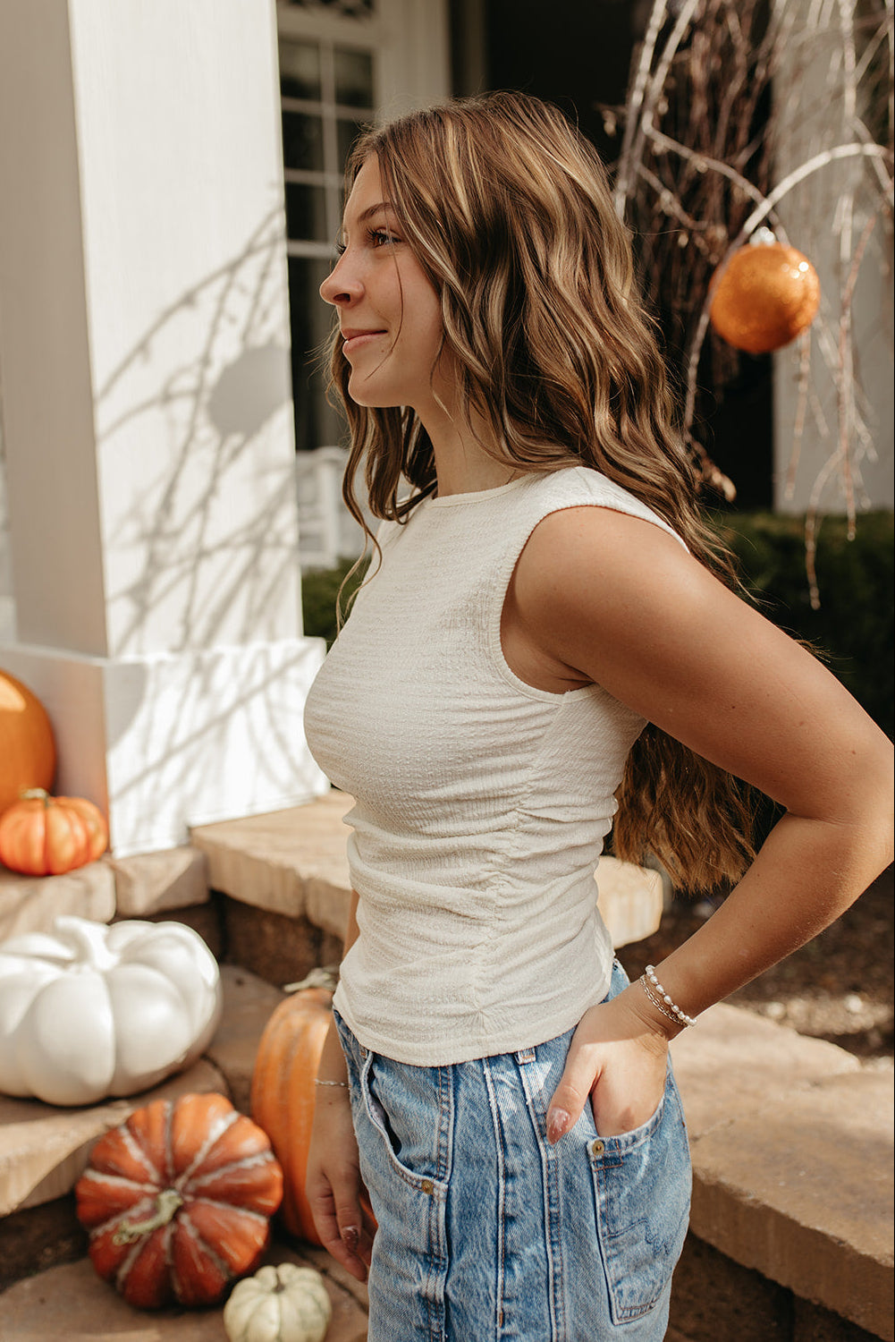 THE KAELI SLEEVELESS TEXTURED RUCHED TOP IN CREAM